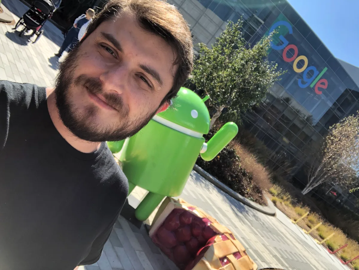 Adriano Rocha at the Googleplex, beside the Android mascot statue